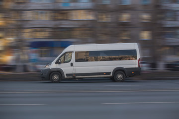 Minibus moves along the road in the city