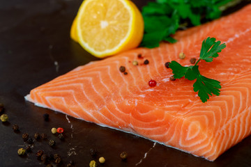 Raw salmon fillets pepper dill lemon and dill on cutting table.
