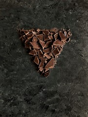 triangle shape chopped chocolate on dark background