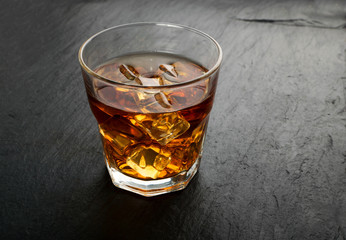 Iced Whiskey Glass on Natural Black Stone Background