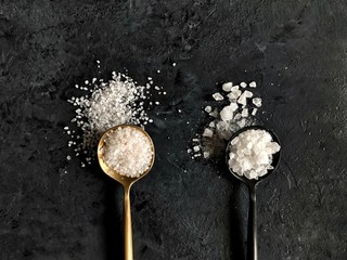 sea salt in spoons on dark background