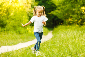 Fototapeta premium A little girl is running in the park