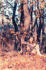 Pretty Young Woman Sitting on Grassy Ground with Dried Leaves Listening Music  Ipod  Headset. Looking at Camera. Isolated  Nature Background.