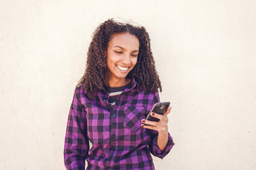 Fototapeta premium Young casual woman using her smartphone