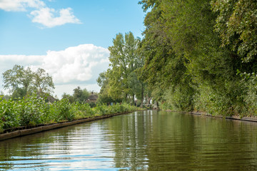 Giethoorn village with canals and rustic thatched roof houses in farm area.