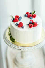 wonderful white cream cake decorated with different berries, close up shot