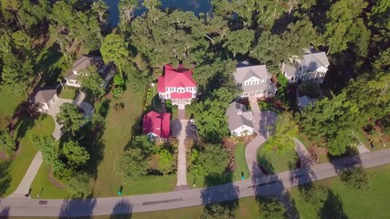 Aerial descending view of waterfront homes with upward pan toward water.