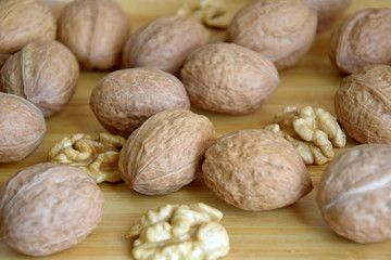 Walnuts and Walnut kernels on wooden background close-up, selective focus