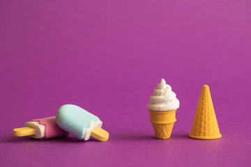 Ice cream on stick and in wafer cone abstract on purple.