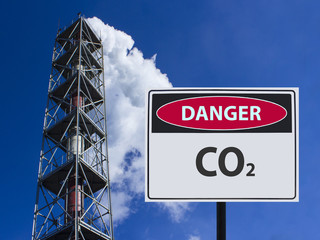 sign of co2 and the factory chimney with smoke in the sky.