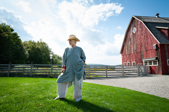 Woman poses in front of barn