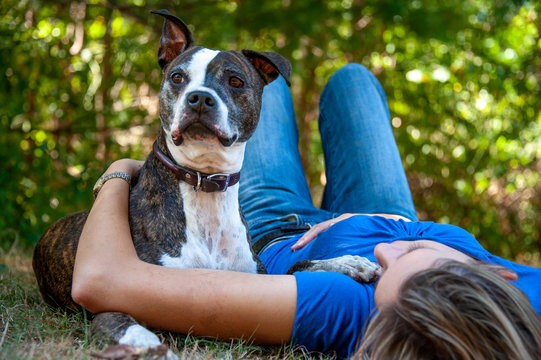 Woman relaxes with pit bull