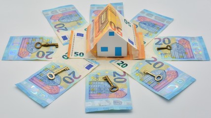 Casa de billetes de euro rodeada de billetes y llaves