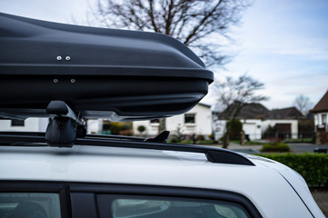 Closed assembled trunk or cargo box on the roof of the car, before a family vacation trip, against...