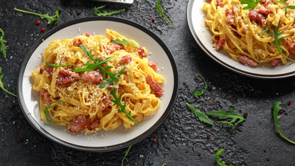 Classic Carbonara pasta, spaghetti with pancetta, bacon, egg, parmesan cheese and green arugula.