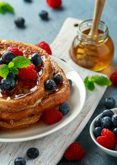 French cinnamon toast with blueberries, raspberries, maple syrup and coffee. morning breakfast