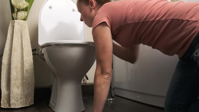 girl is suffering from toxicosis. Vomiting in toilet in bathroom.