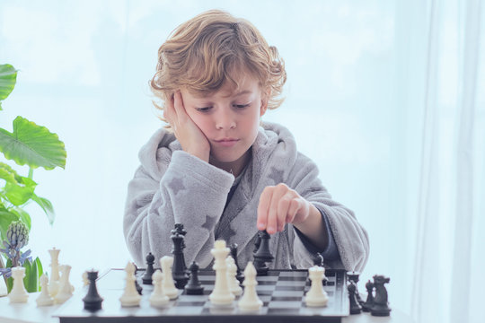 Boy holding figure on chess board