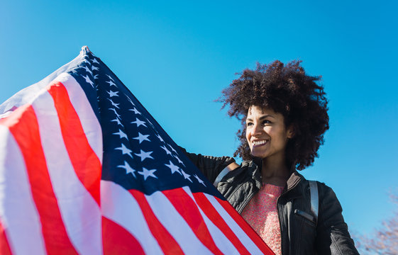 black woman with afro hair and an american flag celebrating the independence day of USA