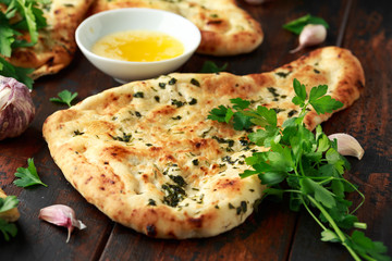 Indian naan bread with garlic butter on wooden table