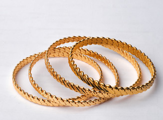 four golden bracelets on white background 