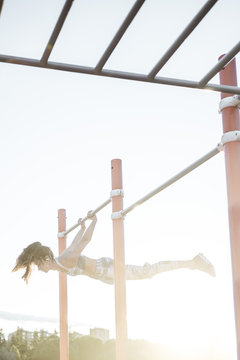 Woman training on parallel bars on street