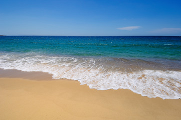 Fototapeta na wymiar Onde frangenti sulla spiaggia dorata di Erbaju in Corsica