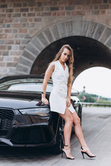 Luxury professional fashion model with new sport car outdoors. Fashion, transport, luxury concept