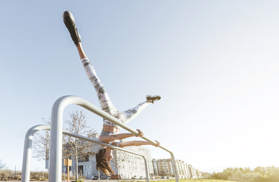 Woman training on parallel bars on street