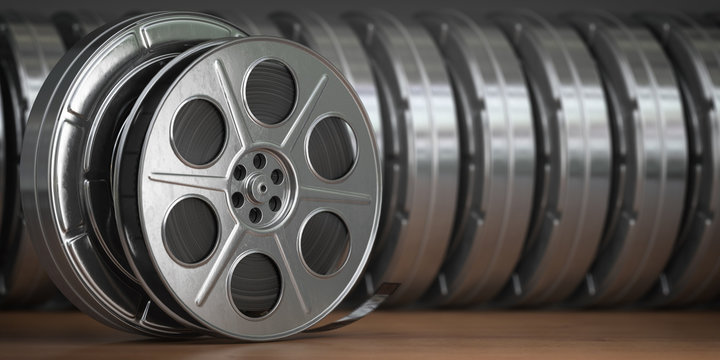 Video, cinema, movie, multimedia concept. A row of vintage film reel or  film spools with filmstrip