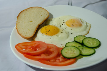 fried chicken eggs with fresh vegetables and bread. Traditional breakfast