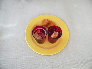 yellow dish with two red plastic cups with lemonade next to nuggets