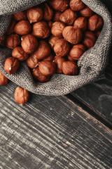 Hazelnuts, filbert in burlap sack on wooden backdrop. heap or stack of hazelnuts. Hazelnut background, healthy food