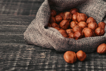 Hazelnuts, filbert in burlap sack on wooden backdrop. heap or stack of hazelnuts. Hazelnut...