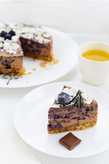 Blueberry - chocolate cheesecake on a white wooden table
