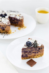 Blueberry - chocolate cheesecake on a white wooden table