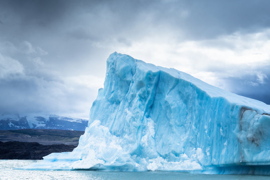 Fantastic view of huge cold iceberg against gray cloudy sky in Argentina