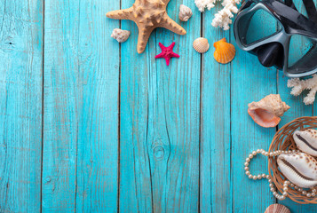 Diving mask with starfish and shells on old blue wooden background. Top view. Flat lay.