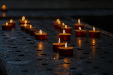 Burning candles on table in church