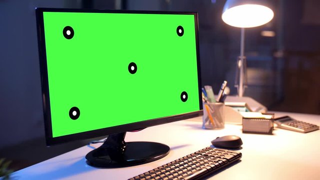 business, deadline and interior concept - computer with chroma key green screen on table at dark night office