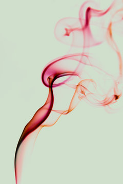Curls of thin red smoke swirling on light green background