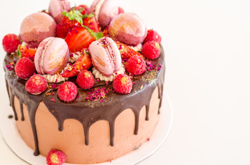 Birthday chocolate cake with strawberries, raspberries and macarons.