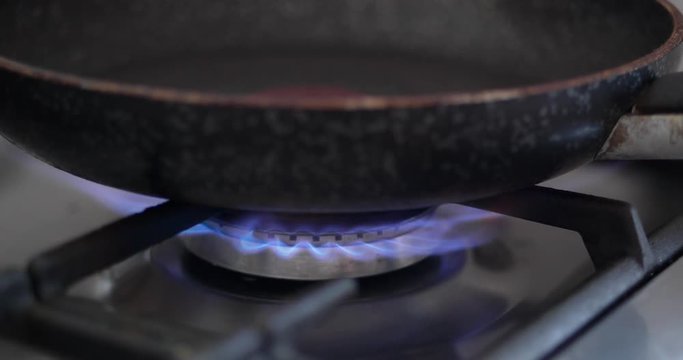 4K - Fire ignition under the frying pan on the gas stove