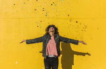 Black woman with afro hair throwing confetti to celebrate a very special day