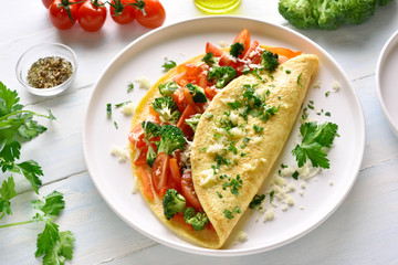 Stuffed omelet with tomatoes, red bell pepper and broccoli