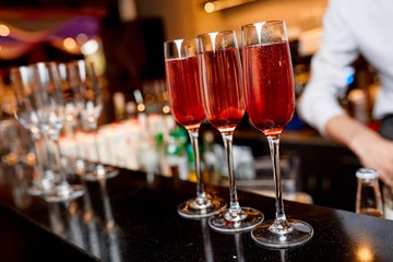 three glasses of pink champagne on the bar in the restaurant