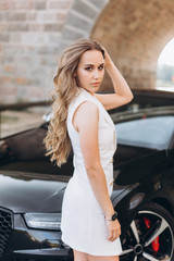 Fototapeta na wymiar Young sexy slim young woman posing outdoors with new sport car outdoors. Fashion, transport, luxury concept 
