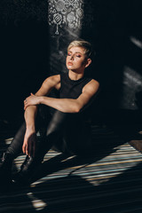 Fashionable portrait of young stylish hipster caucasain girl with haircut in black studio. Sexy, glamourous, gorgeous young woman