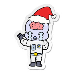 sticker cartoon of a big brain alien crying wearing santa hat