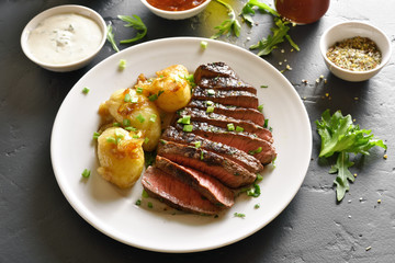 Sliced medium rare roast beef with potato